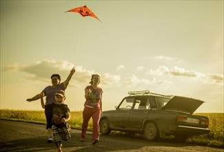 Caucasian family flying kite on rural road