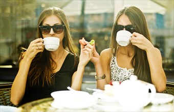 Women having coffee together at sidewalk cafe