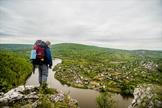 Caucasian hiker admiring scenic view of village