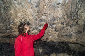 Caucasian woman admiring rock formations in cave