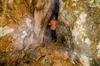 Caucasian woman exploring rock formation cave