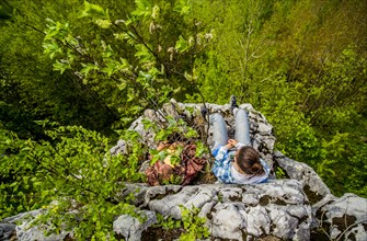High angle view of Caucasian girl sitting on cliff edge