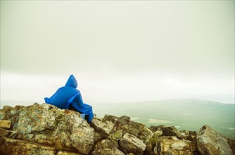 Caucasian hiker sitting on rocky hilltop