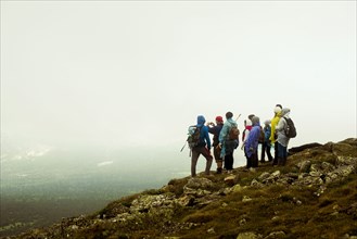 Caucasian hikers standing on rocky hilltop