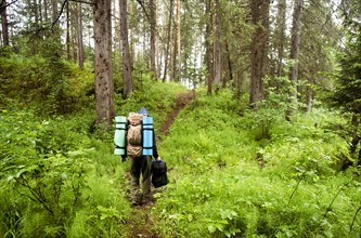 Caucasian hiker carrying backpack in forest