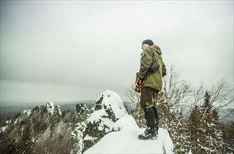 Caucasian hiker standing on snowy hilltop