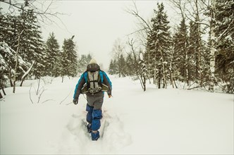 Caucasian hiker walking in deep snow