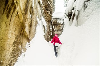 Caucasian hiker exploring snowy rock formations
