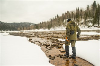 Caucasian hiker walking in rocky remote river