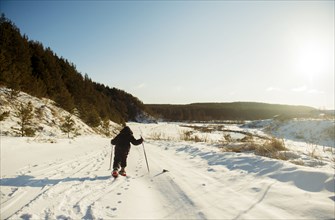 Caucasian boy cross-country skiing in snowy field