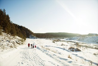 Caucasian family cross-country skiing in snowy field