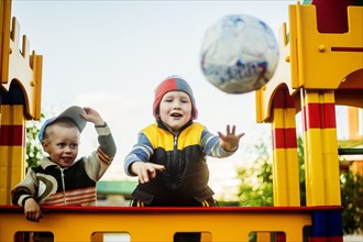 Caucasian boys throwing ball in playground
