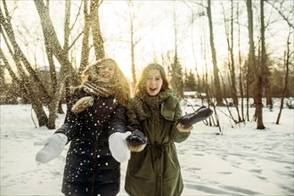 Caucasian women playing in snowy field