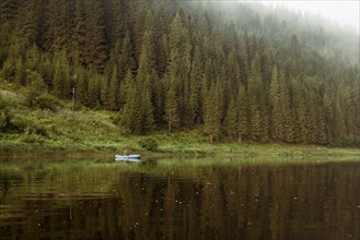 Caucasian man rowing canoe in remote lake