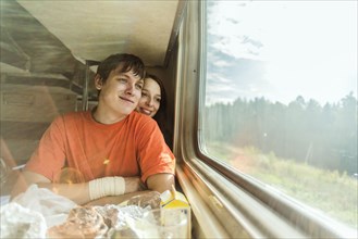 Caucasian couple looking out train window