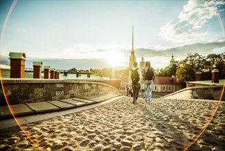 Caucasian tourists walking on cobblestone Leningrad street