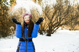 Caucasian girl throwing snow field