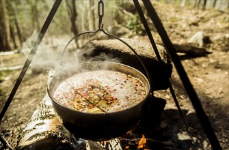 Close up of soup cooking over campfire