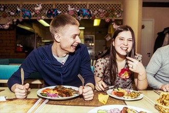 Caucasian couple laughing in restaurant