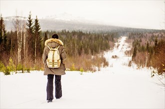 Caucasian man hiking on snowy path