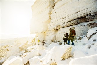 Caucasian hikers walking on snowy rock formations