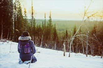 Caucasian hiker admiring scenic view from snowy hillside