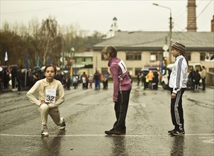 Caucasian children preparing for race on street