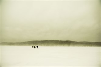 Caucasian hikers walking in snowy remote field