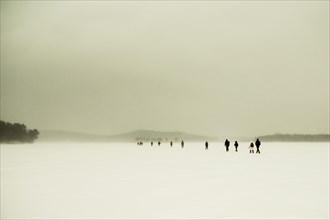Caucasian hikers walking in snowy remote field