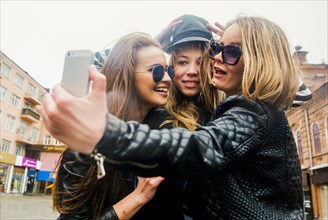 Caucasian women taking selfie in city