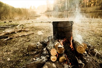 Pot cooking on campfire in rural field