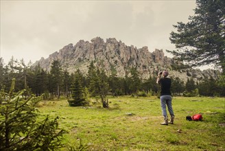 Caucasian hiker photographing mountain in remote landscape