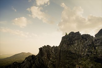 Caucasian hiker sitting on rocky hilltop