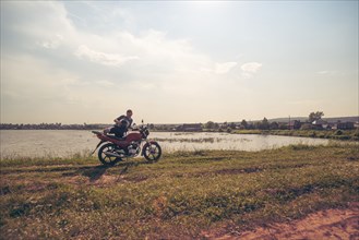 Caucasian man sitting on motorcycle in park