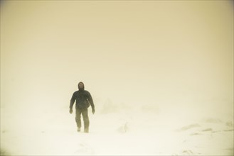 Caucasian hiker walking in snow