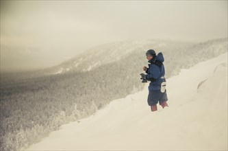Caucasian hiker standing on snowy mountain