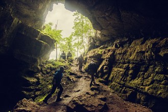 Hikers exploring rock cave