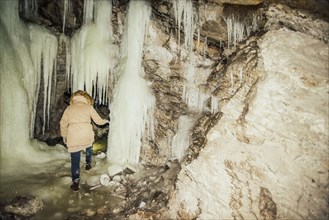 Caucasian woman exploring stalactites in cave