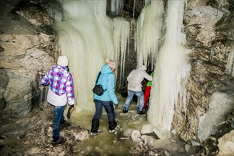Caucasian hikers exploring stalactite cave