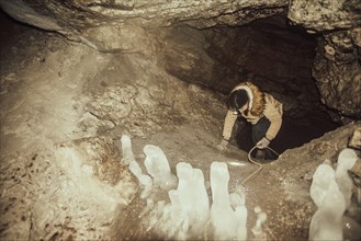 Caucasian hiker climbing in cave