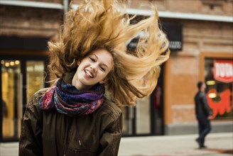 Caucasian woman tossing hair outdoors