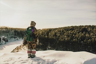 Caucasian hiker standing on snowy hilltop