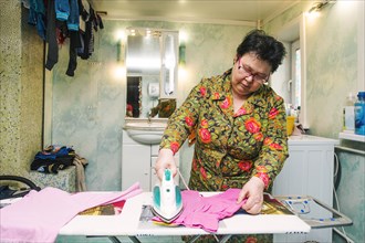 Caucasian woman ironing laundry