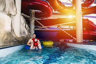 Caucasian father and daughter swimming under water park slide