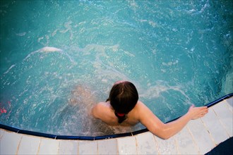 Caucasian woman sitting in swimming pool