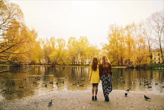 Caucasian women admiring pond in park