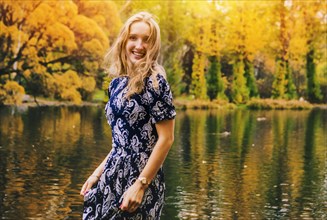 Caucasian woman smiling near pond in park