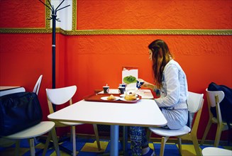 Caucasian woman eating in restaurant