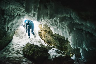 Caucasian hiker walking in icy cave