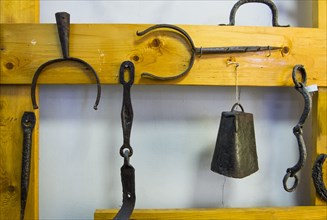 Metal blacksmith products hanging on wood frame